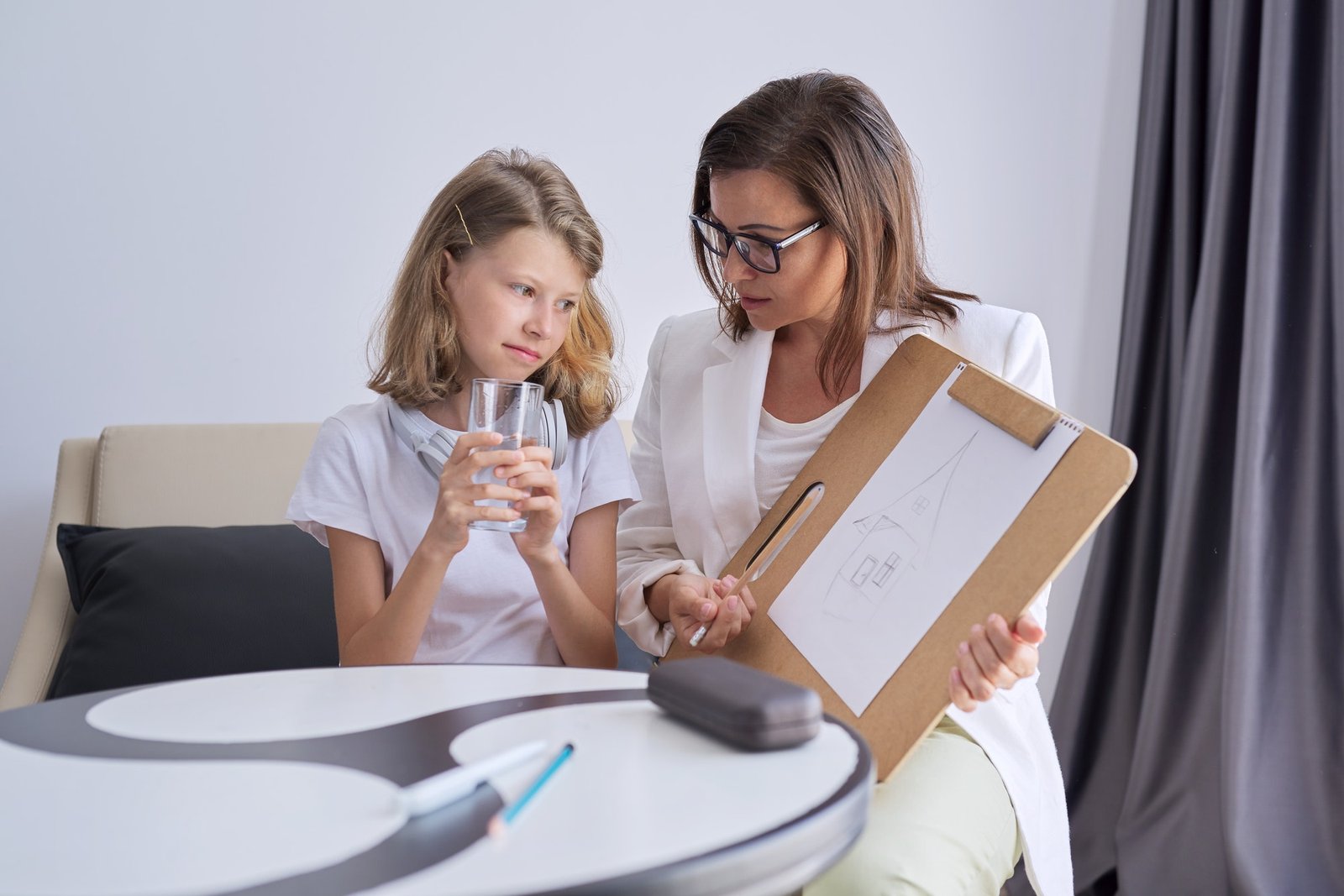 professional-counseling-for-children-psychologist-looks-at-childs-drawing.jpg